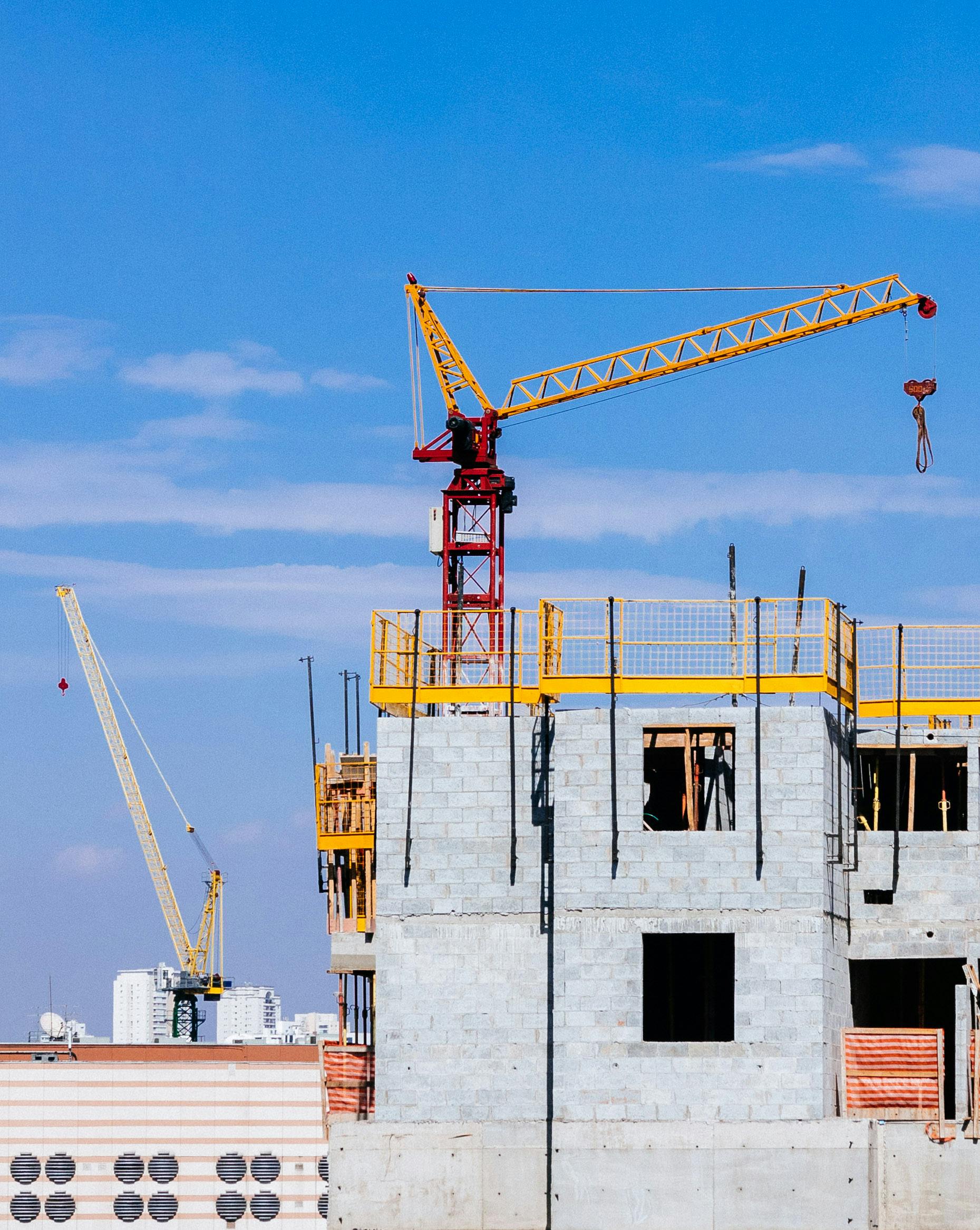 Construction site of a high-rise building with cranes and scaffolding.